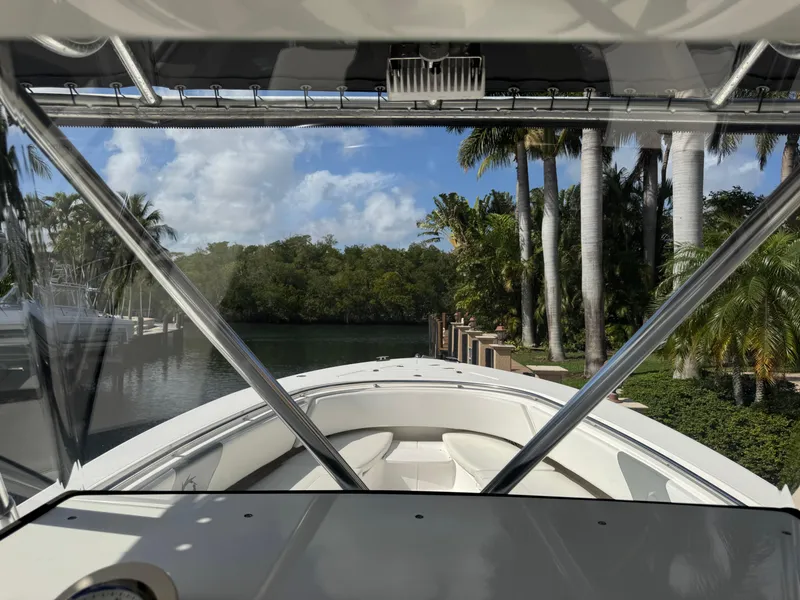 Slide: The Image of 2008 Fountain 34 Center Console boat docked near tropical palm trees and calm water. - 14