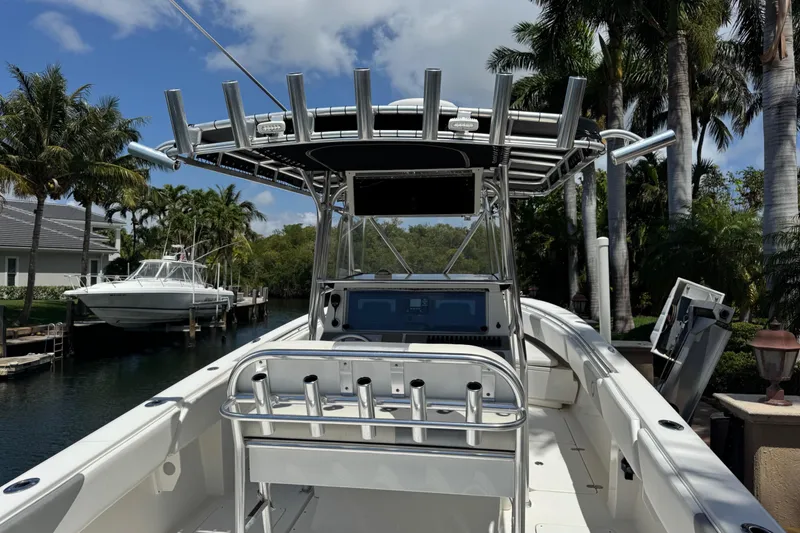 Slide: The Image of 2008 Fountain 34 Center Console boat docked near palm trees and waterfront homes. - 15
