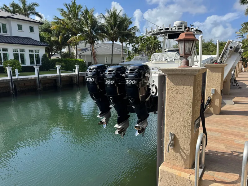 Slide: The Image of 2008 Fountain 34 Center Console with triple 300 horsepower engines docked by waterfront homes. - 2