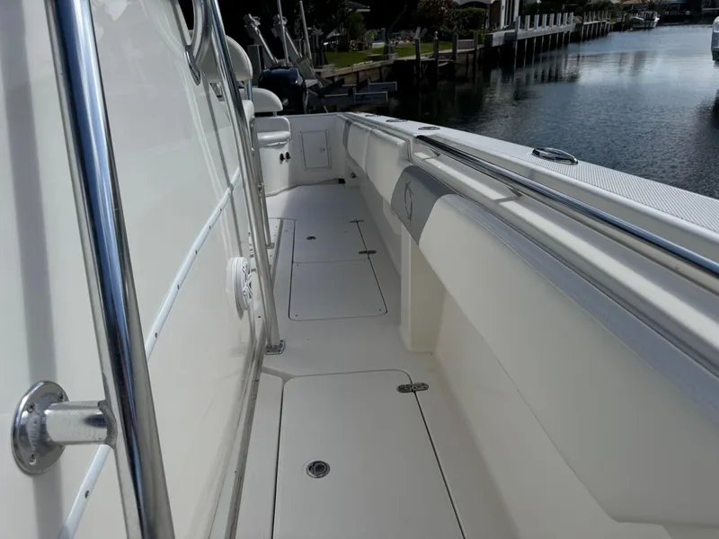 Slide: The Image of 2008 Fountain 34 Center Console boat deck, sleek design, docked by calm water. - 23