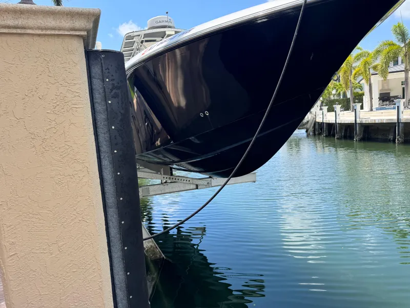 Slide: The Image of 2008 Fountain 34 Center Console boat docked near a waterfront property. - 3