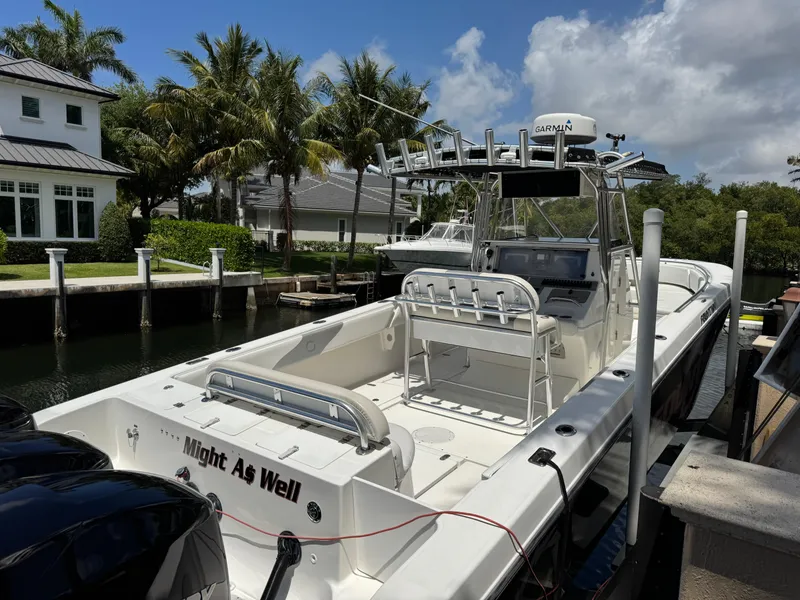 Slide: The Image of 2008 Fountain 34 Center Console boat docked near palm trees and waterfront homes. - 4