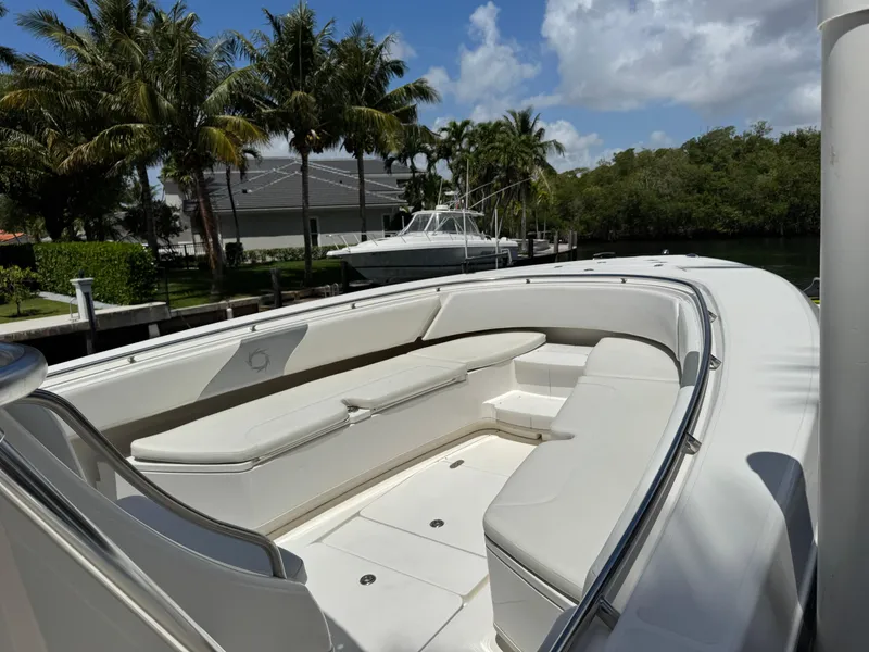 Slide: The Image of 2008 Fountain 34 Center Console boat with spacious seating, docked near palm trees. - 6