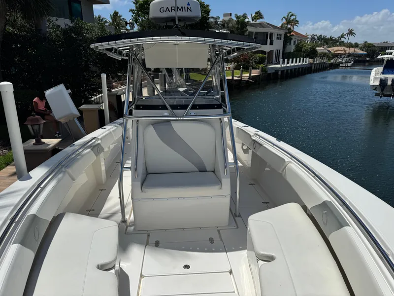 Slide: The Image of 2008 Fountain 34 Center Console boat docked by a canal, featuring spacious seating and Garmin equipment. - 7