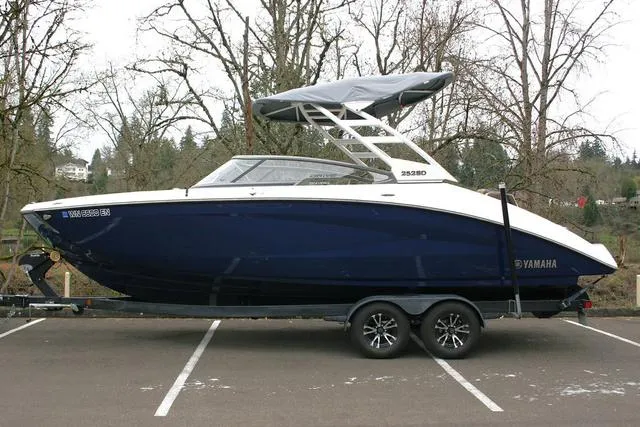 Slide: The Image of 2022 Yamaha Boats 252SD in parking lot, side view, with trailer. - 2