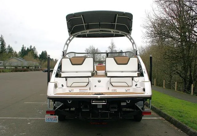 Slide: The Image of 2022 Yamaha Boats 252SD, rear view, parked on a road with trees in the background. - 4