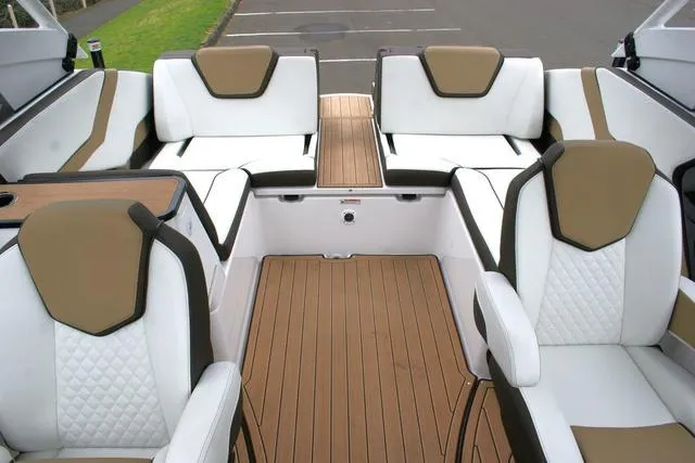 Slide: The Image of 2022 Yamaha Boats 252SD interior with white and tan seating, wood-style flooring. - 8