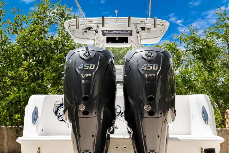 Slide: The Image of 2024 Contender 35 ST boat with twin 450 HP engines, set against a clear blue sky. - 11
