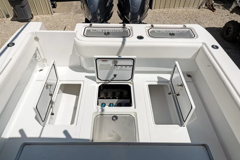 Slide: The Image of 2024 Contender 35 ST boat deck with open storage compartments and dual engines. - 33