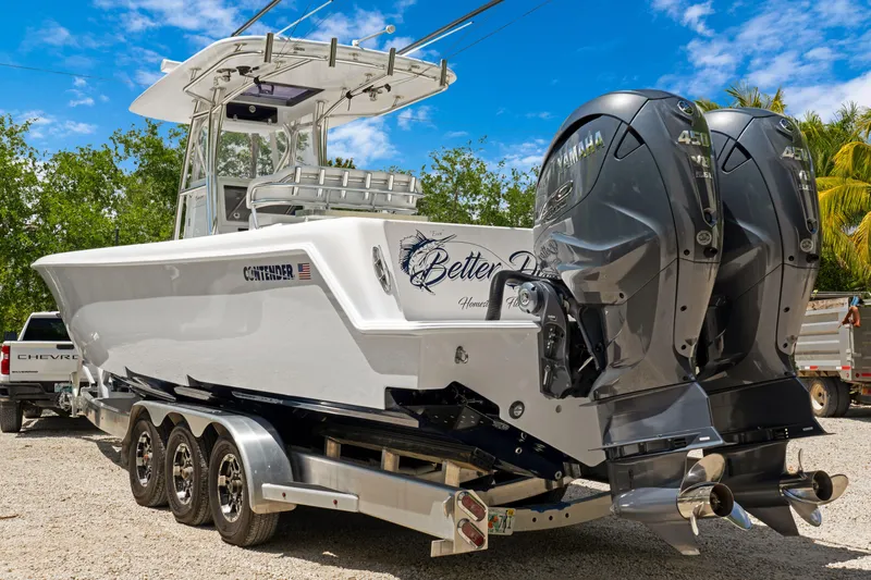 Slide: The Image of 2024 Contender 35 ST boat with dual Yamaha engines on a trailer, parked outdoors. - 4