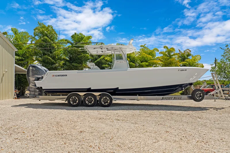 Slide: The Image of 2024 Contender 35 ST boat on trailer, parked outdoors under blue sky. - 8