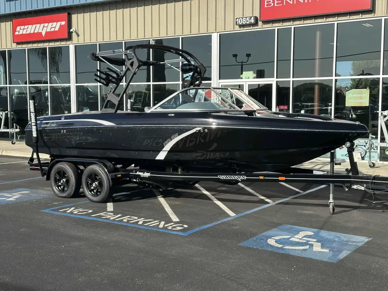 Slide: The Image of 2025 Sanger V215 SX boat on trailer outside dealership. - 1