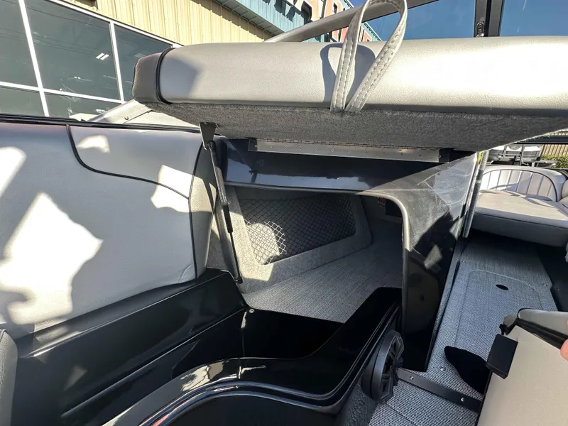 Slide: The Image of 2025 Sanger V215 SX boat interior storage compartment with open seat and modern design. - 13
