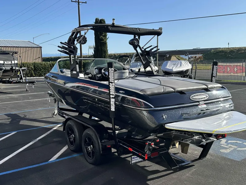 Slide: The Image of 2025 Sanger V215 SX boat on trailer in parking lot, sunny day. - 17