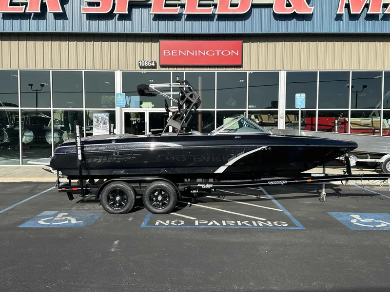 Slide: The Image of 2025 Sanger V215 SX boat on trailer outside dealership. - 2