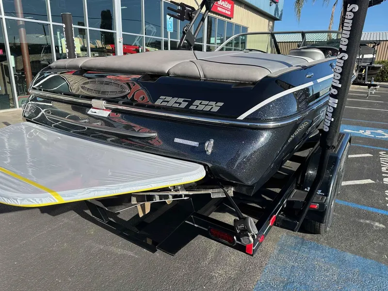 Slide: The Image of 2025 Sanger V215 SX boat on trailer at dealership parking lot. - 21