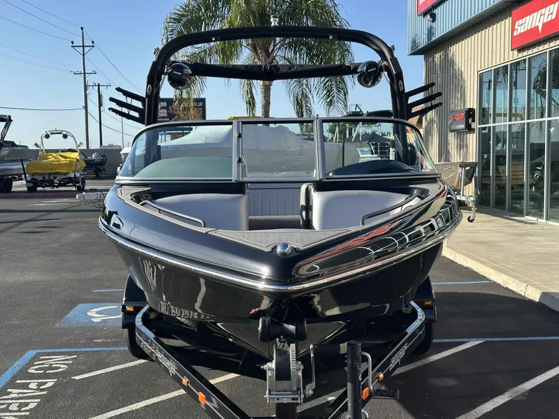 Slide: The Image of 2025 Sanger V215 SX boat on trailer, parked outside dealership. - 4