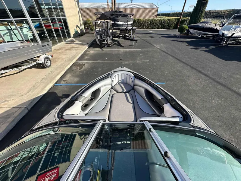Slide: The Image of 2025 Sanger V215 SX boat with sleek interior, parked in a dealership lot. - 5