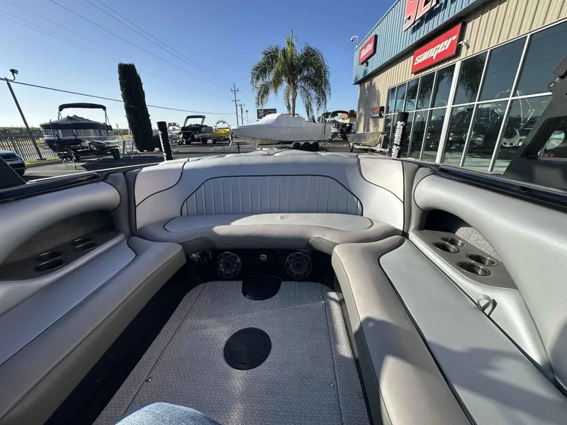 Slide: The Image of 2025 Sanger V215 SX boat interior with gray seating and cup holders, displayed outdoors. - 7