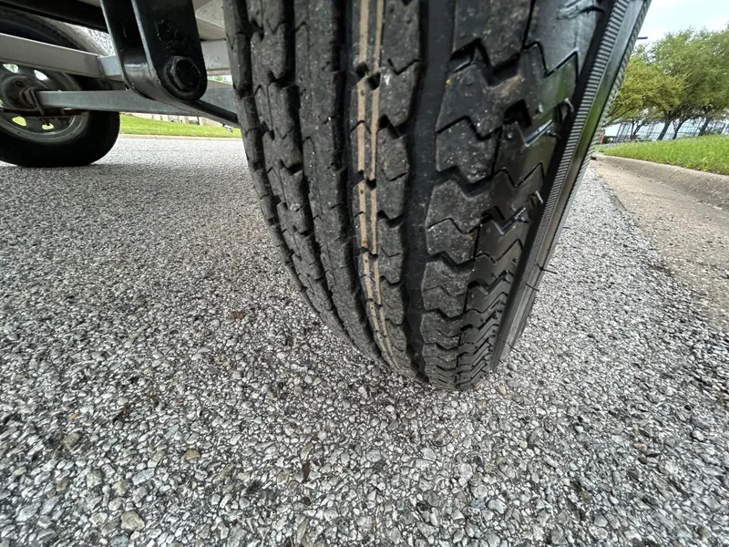 Slide: The Image of Close-up of a 2017 Carolina Skiff JVX Pre-Rig Series 18 trailer tire on gravel road. - 30