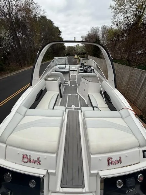 Slide: The Image of 2013 Regal 2700 Bowrider boat with spacious seating and sleek design on a road. - 10