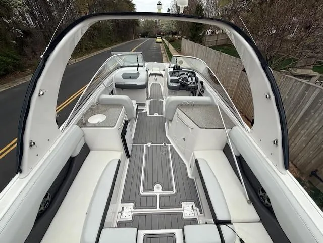 Slide: The Image of 2013 Regal 2700 Bowrider boat with spacious seating and sleek design on a road. - 13