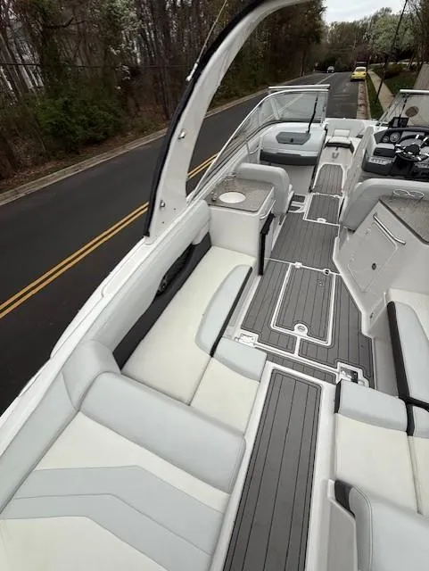 Slide: The Image of 2013 Regal 2700 Bowrider boat with spacious seating and sleek design on a road. - 15