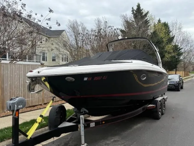 Slide: The Image of 2013 Regal 2700 Bowrider boat on trailer, parked on residential street. - 2