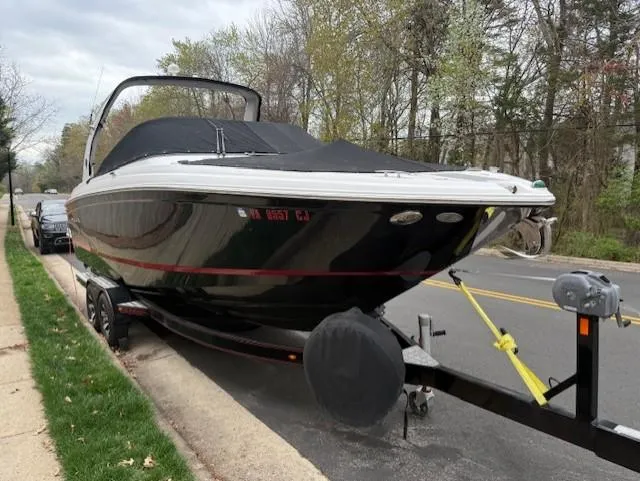 Slide: The Image of 2013 Regal 2700 Bowrider boat on trailer, parked on roadside, covered and secured. - 3