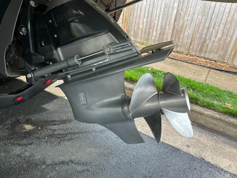 Slide: The Image of Propeller of 2013 Regal 2700 Bowrider boat on pavement near wooden fence. - 46