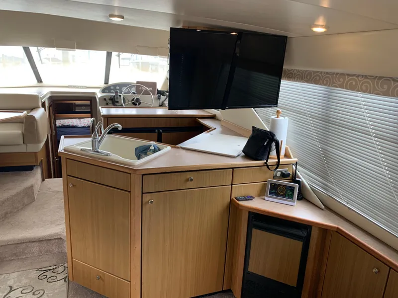 Slide: The Image of Interior of 2000 Bayliner 3988 yacht with kitchenette, TV, and helm station. - 10