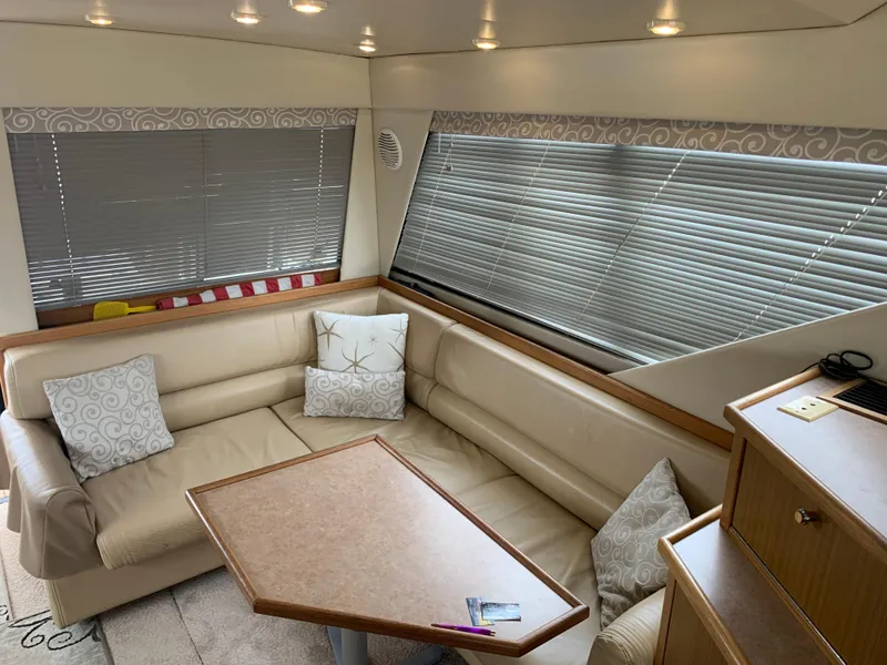 Slide: The Image of Interior of 2000 Bayliner 3988 yacht with beige seating and wooden table. - 12