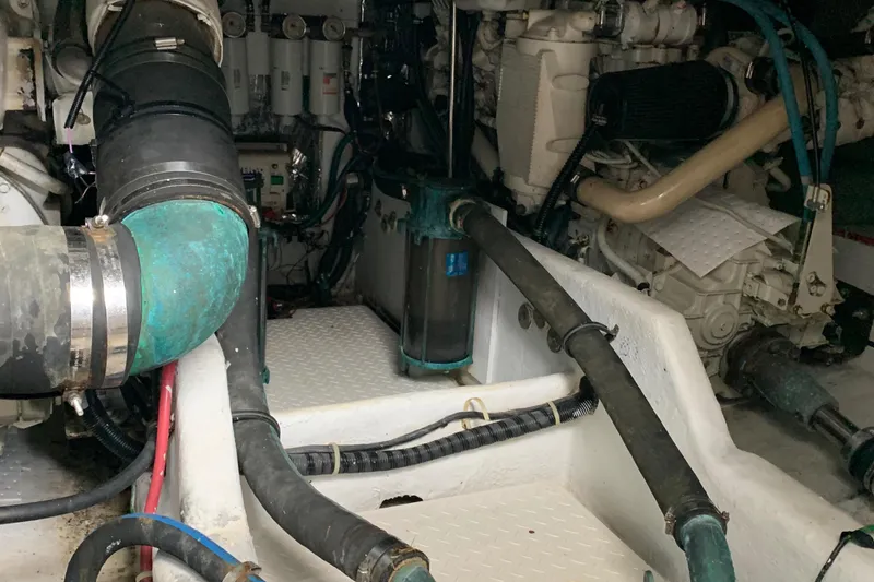Slide: The Image of Engine room of a 2000 Bayliner 3988 boat, showcasing mechanical components and piping. - 30