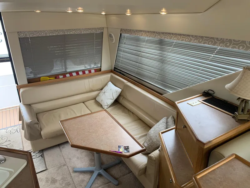 Slide: The Image of Interior of 2000 Bayliner 3988 yacht with beige seating and wooden table. - 4