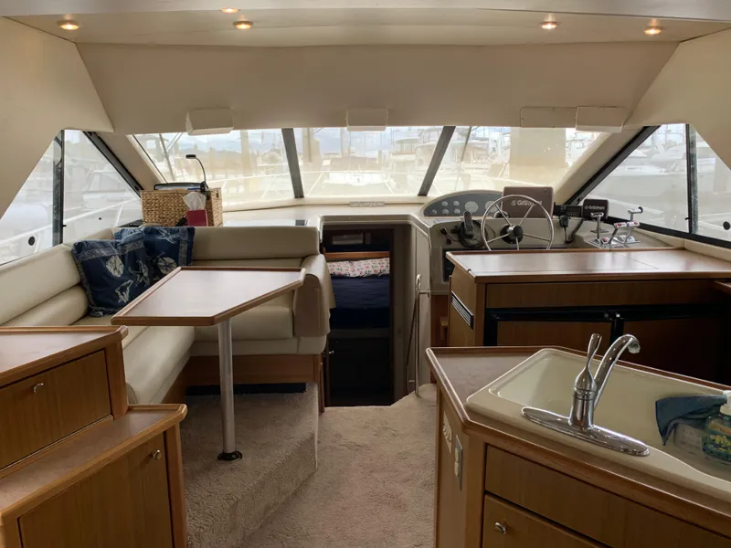 Slide: The Image of Interior of 2000 Bayliner 3988 yacht with seating, table, and kitchenette. - 7