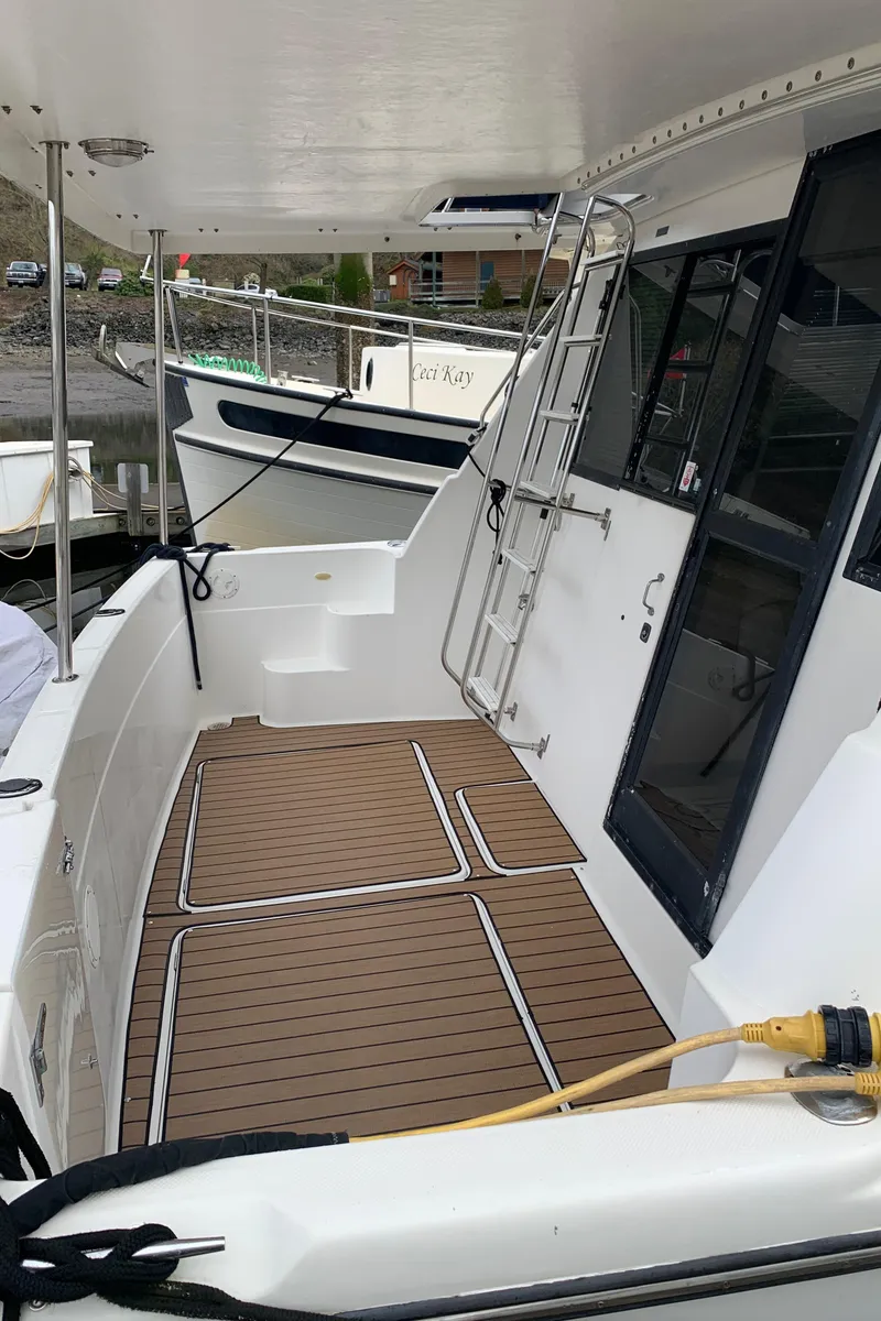 Slide: The Image of 2000 Bayliner 3988 yacht deck with teak flooring and ladder. - 8