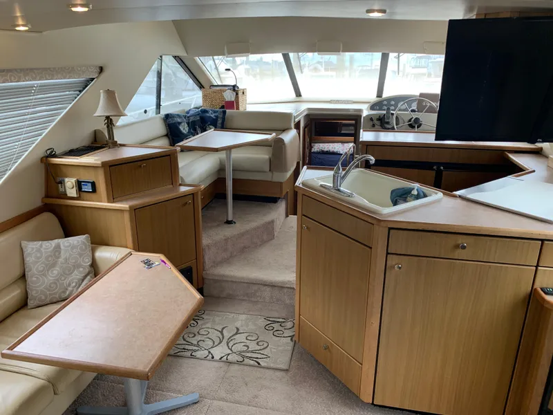 Slide: The Image of Interior of 2000 Bayliner 3988 yacht with seating, tables, and kitchenette. - 9