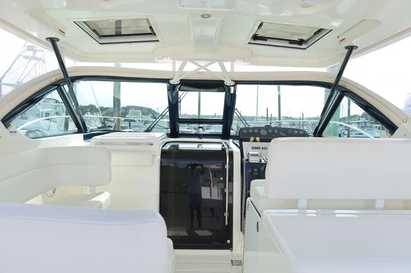 Slide: The Image of 2009 Tiara Yachts 32 Open cockpit with helm, white seating, and marina view. - 10