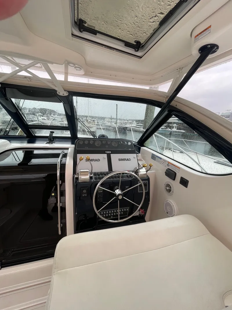 Slide: The Image of 2009 Tiara Yachts 32 Open helm with Simrad navigation, steering wheel, and cushioned seating. - 14