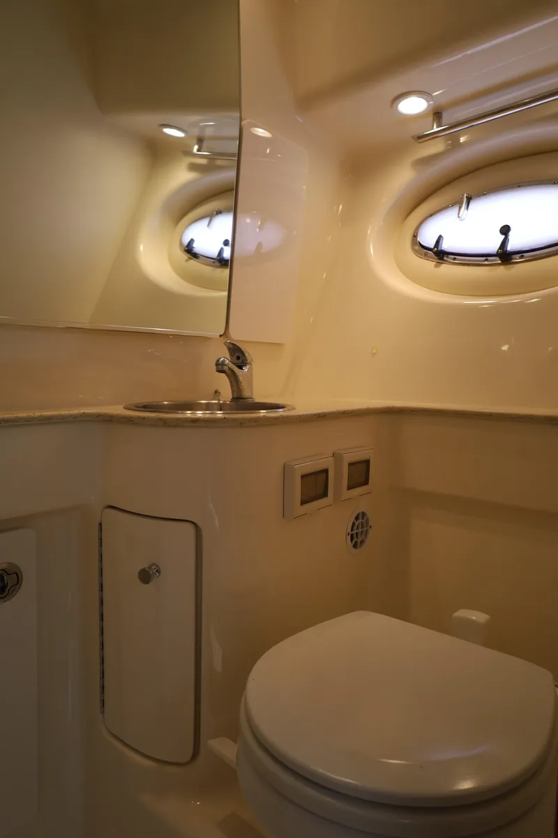Slide: The Image of 2009 Tiara Yachts 32 Open bathroom with sink, toilet, and porthole window. - 22