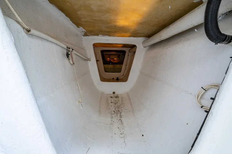 Slide: The Image of Interior view of 2019 Aventura 31 Cat boat compartment, featuring white walls and ceiling hatch. - 10