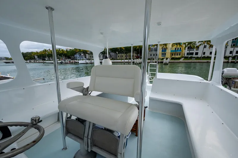 Slide: The Image of 2019 Aventura 31 Cat interior with white seating, steering wheel, and waterfront view. - 15