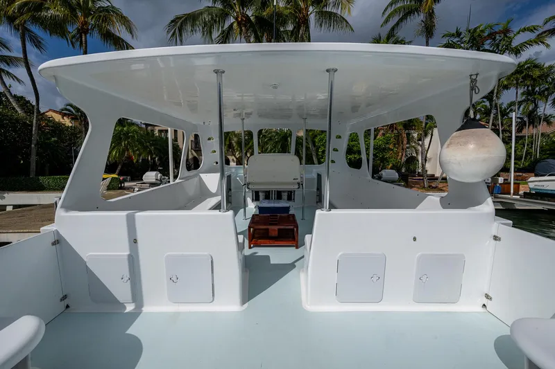 Slide: The Image of 2019 Aventura 31 Cat boat with spacious deck and canopy, surrounded by palm trees. - 21