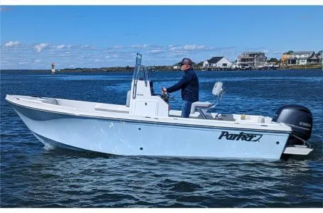 Slide: The Image of A 2025 Parker 18SE boat cruising on a calm sea near a coastal town. - 3