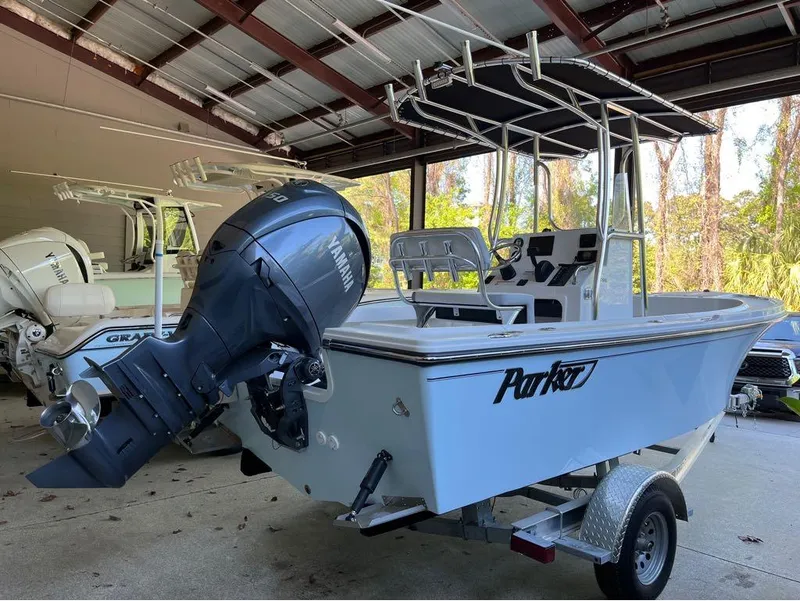 Slide: The Image of 2025 Parker 18SE boat with Yamaha outboard motor in a covered storage area. - 7