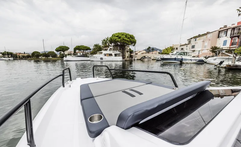 Slide: The Image of 2025 Axopar 25 Cross Top boat docked in a scenic marina. - 3