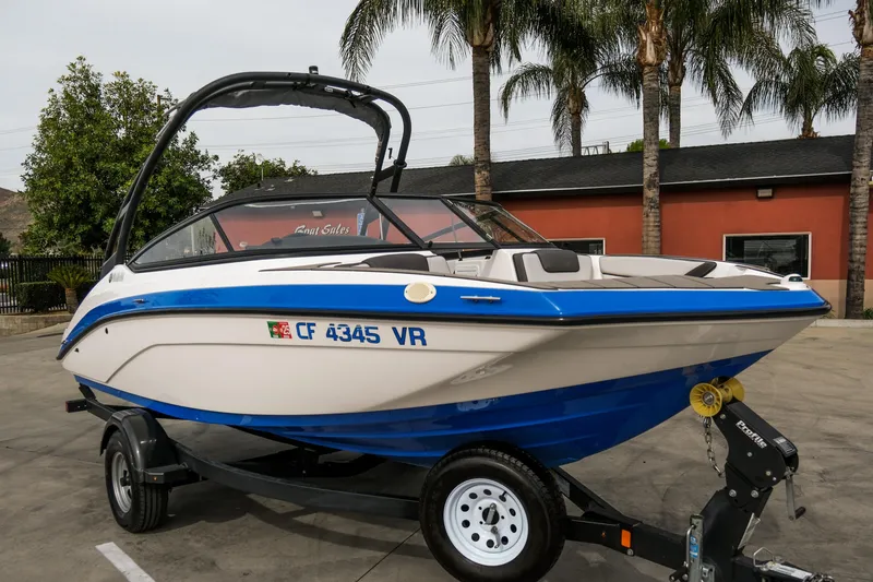 Slide: The Image of 2019 Yamaha Boats AR 190 on trailer, parked outdoors with palm trees in background. - 1