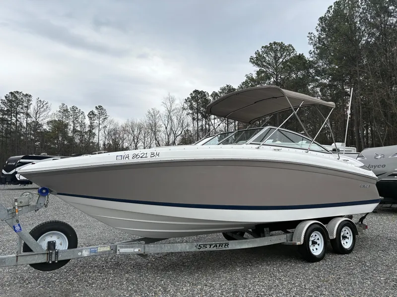 Slide: The Image of 2007 Cobalt 232 Bowrider boat on trailer, parked outdoors with trees in background. - 1