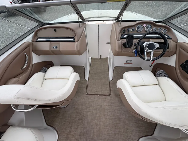 Slide: The Image of 2007 Cobalt 232 Bowrider interior with beige and white seating, dashboard, and steering wheel. - 19