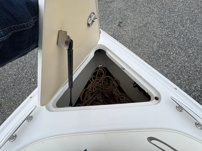 Slide: The Image of Open storage compartment on 2007 Cobalt 232 Bowrider boat, containing coiled rope. - 21